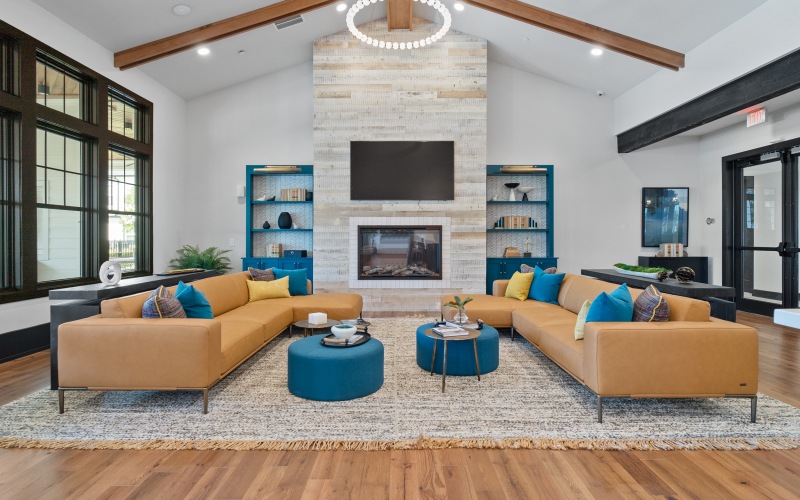 a room with a tv above a fireplace and a table with chairs and a couch